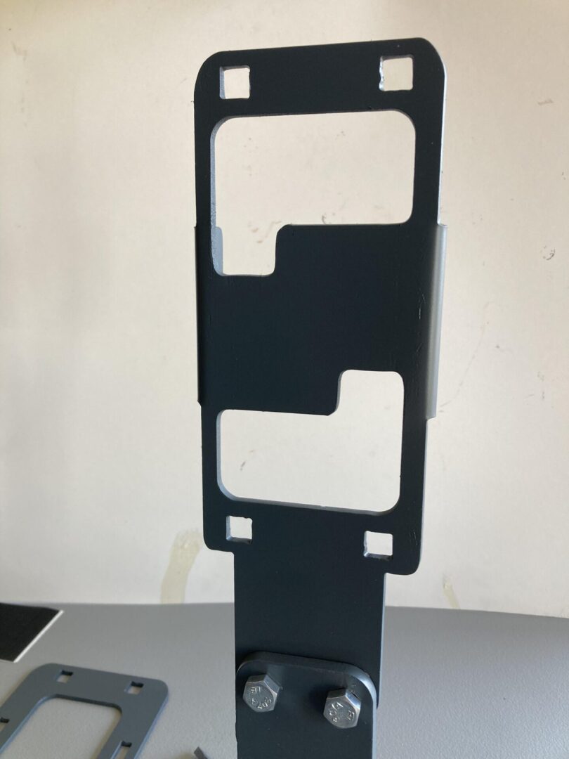 A metal Phone Mount bracket with two screws on it.